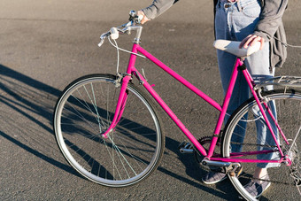 认不出来年轻的女人粉红色的复古的自行车