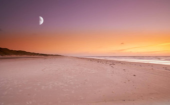 复制空间海月亮《暮光之城》晚上天空平静海洋波放松海滩海岸风景优美的和平全景美丽的日落月球背景空景观