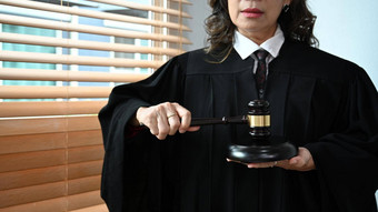 自信高级法官袍礼服统一的持有槌子手律师正义法律律师概念