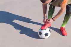 足球球员系靴子脚球