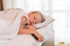 睡眠年轻的美丽的移动电话女孩床上毯子视图卧室白色枕头人首页床上用品健康的放松在室内呼吸放松