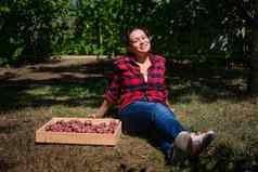 愉快的女人农民休息草农村房子后院收获作物新鲜的有机土豆