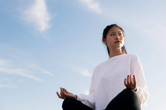 美丽的年轻的亚洲女人坐着冥想