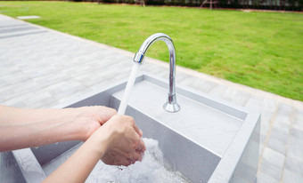 女人洗手利用水水龙头白色水槽洗手利用水户外水槽草场个人卫生防止冠状病毒科维德健康的生活方式