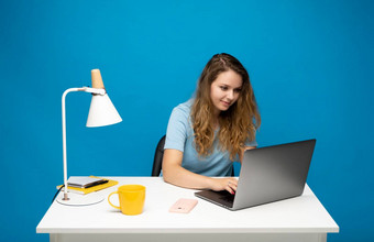 快乐年轻的自由职业者卷曲的女人蓝色的t恤工作移动PC电脑说话客户端朋友使者工作项目自由工人