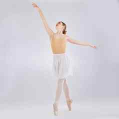 美跳舞工作室拍摄年轻的女人执行芭蕾舞独奏会灰色背景