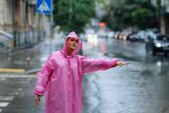 年轻的女孩停止出租车女人调用出租车多雨的一天