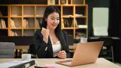 快乐亚洲女企业家移动PC屏幕庆祝业务成功胜利