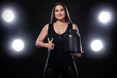 快乐健康的肌肉发达的年轻的健身体育女人运动员Jar体育营养蛋白质获得者酪蛋白黑色的背景
