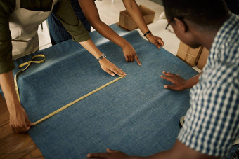 时尚设计风格专业团队测量织物有创意的纺织车间裁缝的同事们创建时尚的时尚服装工厂