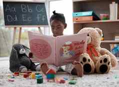 玩具书可爱的女孩阅读书坐着首页