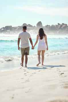 海滩漫步年轻的夫妇享受一天海滩
