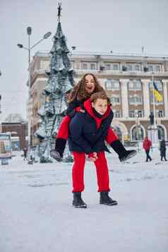 年轻的家庭的家伙女孩花一天公园雪一天情感年轻的夫妇有趣的走冬天城市活泼的男人。拥抱笑美丽的女人