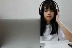 女孩穿耳机研究在线电脑移动PC听放松音乐玩互联网社会媒体首页