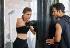 适合女学习拳击冲袋健身培训建议个人教练健身房工作室强大的拳击手苗条的身体练习战斗战斗教练