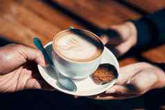 特写镜头手持有给卡布奇诺咖啡平白色客户咖啡馆热饮料有创意的植物图像牛奶泡沫早....咖啡喝使咖啡师餐厅