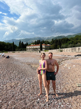 男人。女人泳衣站海滩别墅米洛瑟黑山共和国