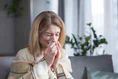 生病的女人坐着沙发上首页咳嗽发热冷流鼻涕的鼻子