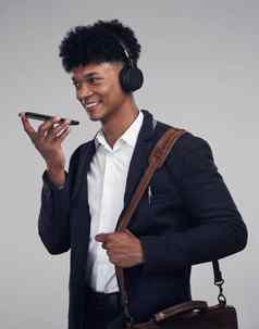 旅行企业家虚拟助理工作室拍摄年轻的商人智能手机耳机灰色背景