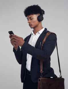 播客专业联系工作室拍摄年轻的商人智能手机耳机灰色背景