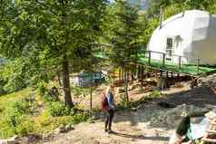 女人自然地理圆顶帐篷绿色蓝色的橙色背景舒适的野营豪华露营假期假期生活方式概念风景优美的在户外小屋