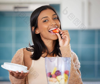 选择食物滋养身体年轻的女人吃草莓准备健康的奶昔首页