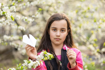 特写镜头视图图像女孩玩<strong>纸飞机</strong>公园可爱的孩子扔<strong>纸飞机</strong>在户外花园童年概念
