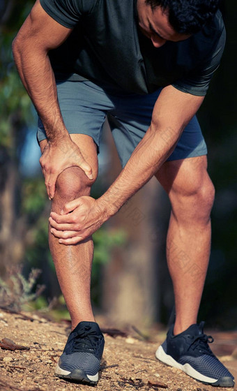 经历位疼痛<strong>刚度</strong>膝盖运动年轻的男人。持有膝盖疼痛锻炼在户外