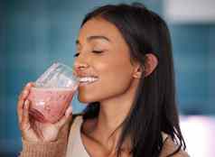 新鲜的冰沙滋养身体至关重要的维生素年轻的女人喝健康的奶昔首页