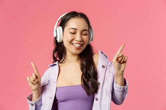 生活方式音乐技术概念特写镜头肖像无忧无虑的快乐微笑亚洲女人享受最喜欢的歌手首歌跳舞关闭眼睛听歌曲耳机