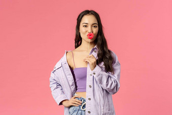 假期生活方式人概念肖像时髦的有吸引力的时尚的现代亚洲女孩持有接吻嘴唇坚持使自信表达显示的态度粉红色的背景