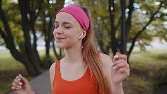 肖像运动体育运动跑步者女孩培训听最喜欢的音乐首歌耳机公园