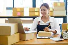 亚洲女商人开始小业务老板写作地址纸板盒子