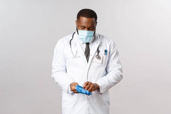 医学科维德治疗医院概念严肃的表情专业非裔美国人医生制造口罩准备好了治疗病人生病的冠状病毒症状把医疗乳胶手套