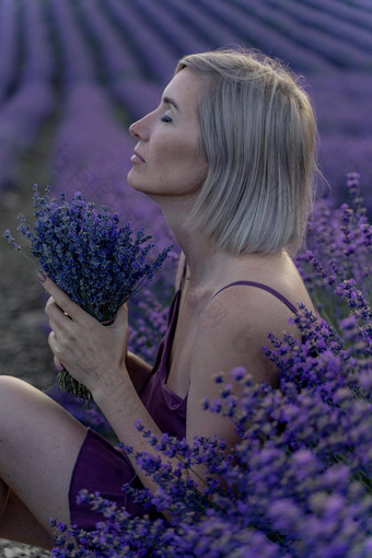 中年女人坐在<strong>薰衣草</strong>场享受芳香疗法芳香疗法概念<strong>薰衣草</strong>石油照片会话<strong>薰衣草</strong>