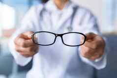 特写镜头照片医生的手持有眼镜眼科医生提供了眼镜病人