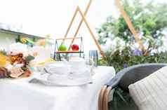 咖啡杯花花束表格花园下午茶概念首页户外家具柳条椅子表格白色桌布古董风格舒适的椅子表格阳台