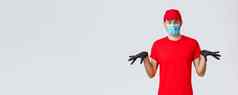 科维德self-quarantine在线购物航运概念有趣的快递黑色的橡胶手套脸面具交付的家伙统一的手势不情愿的站灰色背景