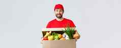 食品杂货包交付科维德检疫购物概念微笑交付男人。红色的统一的带客户端订单持有食物盒子包裹享受人转移货物