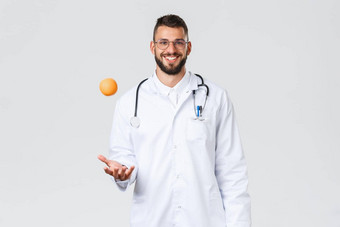 医疗保健工人医疗保险诊所实验室科维德概念快乐的微笑拉美裔医生医生白色外套扔橙色推荐吃健康的维生素水果