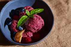 前视图美味的健康的生素食主义者浆果冰沙成熟的多汁的水果柠檬罗勒叶子蓝色的陶瓷碗
