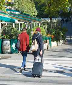 女人旅行者旅行手提箱行李走街巴黎