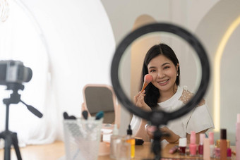 亚洲年轻的女博主记录视频博客视频化妆<strong>化妆品首页</strong>在线影响者社会媒体概念生活流媒体病毒