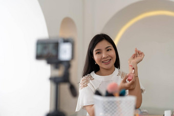 亚洲年轻的女博主记录视频博客视频化妆化妆品首页在线影响者社会媒体概念生活流媒体病毒