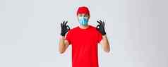 科维德self-quarantine在线购物航运概念兴奋交付的家伙红色的帽t恤脸面具工作冠状病毒爆发显示标志保证安全快递服务