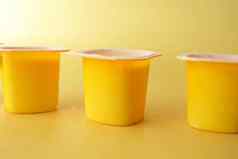 新鲜的酸奶黄色的颜色塑料容器