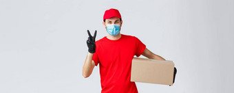 包包裹交付科维德检疫交付转移订单友好的快递红色的统一的脸面具手套交付订单客户端持有盒子显示和平标志