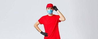 科维德self-quarantine在线购物航运概念交付的家伙红色的统一的触碰帽耶和华见证人客户工作冠状病毒爆发穿医疗面具保护手套