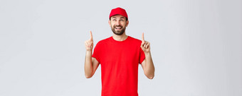 在线购物交付检疫外卖概念快乐的兴奋快递红色的统一的帽t恤微笑惊讶指出手指阅读横幅标志