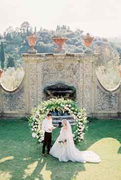新郎读取誓言新娘婚礼拱前面石头墙